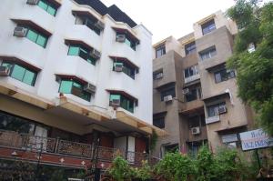 an apartment building with balconies and trees at Hotel Vice President in Ahmedabad