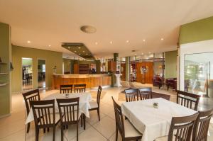 a restaurant with tables and chairs and a bar at Novum Hotel Seegraben Cottbus in Cottbus