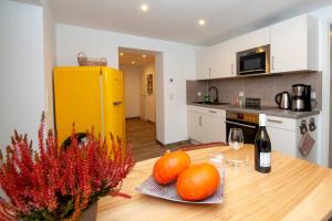 a kitchen with a table with oranges and a yellow refrigerator at Ferienwohnung am Schloss in Wernigerode