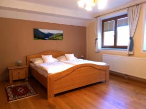 um quarto com uma cama de madeira e uma janela em Ferienwohnung Schlögelhofer em Lunz am See