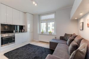 a living room with a couch and a kitchen at Imperial Apartments - Marina in Sopot
