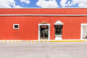een rood gebouw met een bord dat hotel leest bij Hotel Rath in Campeche
