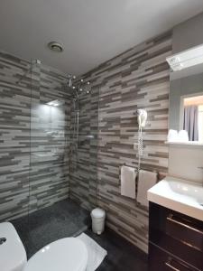een badkamer met een douche, een toilet en een wastafel bij l'Hotel du port in Port-la-Nouvelle