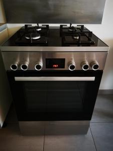 a black stove top oven in a kitchen at Maison récente calme 24 heures du Mans 9 couchages in Le Mans