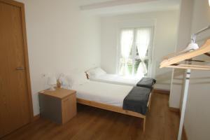 a bedroom with a bed with white sheets and a window at APARTAMENTO LABEGAIN 2 in Sestao