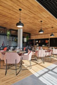 a dining room with tables and chairs in a restaurant at Ibis Montlhery Paris Sud in Montlh&eacute;ry