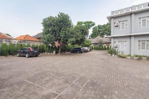 a parking lot with cars parked next to a building at RedDoorz At Hotel Arimbi Dewi Sartika Baru in Bandung