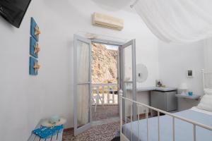 Schlafzimmer mit einer Tür, die auf einen Balkon führt in der Unterkunft Sagma Beach Rooms in Perissa