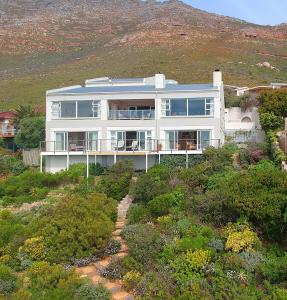 a large white house sitting on top of a hill at Avian Leisure in Simonʼs Town