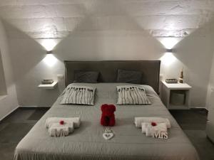 a bed with a red teddy bear on it at Casa Vacanze Antiche Mura E Poi in Monopoli