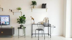 een kamer met een stoel en planten aan een muur bij No.10 The Vintage @ Diffrent Home Feeling in Puchong