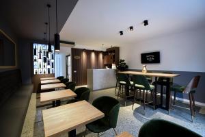 a restaurant with wooden tables and green chairs at Hotel LoRa in Belgrade