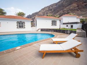 a villa with a swimming pool with two lounge chairs at Bungalows Los Roques de Salmor in Las Puntas +32 photos