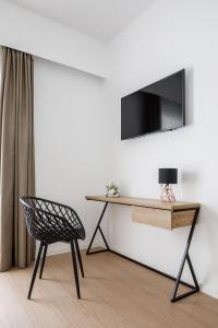 una silla y un escritorio con TV en la pared en Hotel Torá, en Paguera