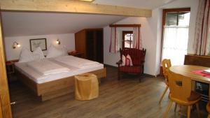 a bedroom with a bed and a desk and a table at Apartments Röck in Neukirchen am Großvenediger
