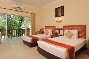 a hotel room with two beds and a balcony at Heritage Hotel in Anuradhapura
