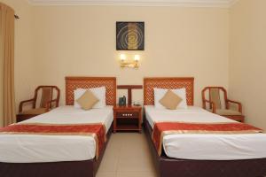 a hotel room with two beds in a room at Heritage Hotel in Anuradhapura