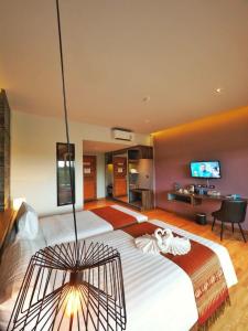 a bedroom with a large bed with a tv on the wall at The Glory Gold in Khao Lak