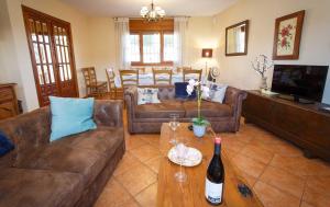 a living room with couches and a table with a bottle of wine at El Bulín de Aldealengua in Ceguilla
