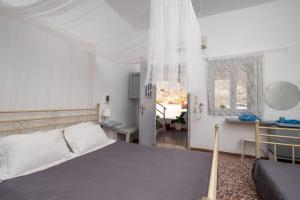 Un dormitorio con una cama y un escritorio y una ventana. en Sagma Beach Rooms, en Perissa
