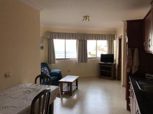 salon ze stołem oraz pokój z kuchnią w obiekcie Gomera Sunset Apartments w mieście Valle Gran Rey