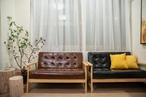 a living room with a leather couch and a window at The Chambers in Tainan