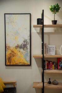 a painting hanging on a wall next to a shelf at The Chambers in Tainan