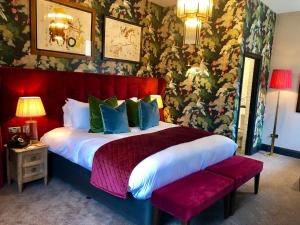a bedroom with a large bed with a red headboard at The Park Hotel in Teddington