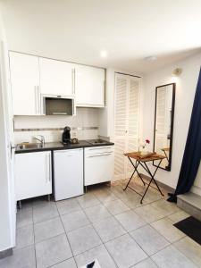 a kitchen with white cabinets and a tile floor at STUDIO COSY LE Ti PARIS WIFI & NETFLIX in Deuil-la-Barre
