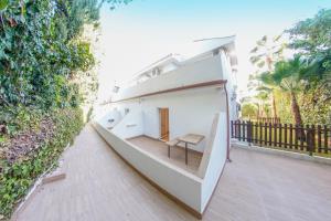 a large white house with a balcony with a bench at Hotel Zen Airport in Torremolinos