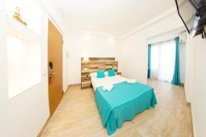 een slaapkamer met een groot bed en een blauwe deken bij Hotel Zen Airport in Torremolinos
