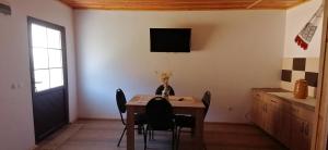阿夫里格的住宿－Domeniul Roa，一间设有桌子和墙上电视的用餐室