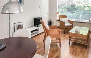 - un salon avec une table, des chaises et une télévision dans l'établissement Beautiful Home In Julianadorp With Kitchen, à Julianadorp