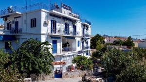 a white building with blue doors and windows at Aphrodite Art Hotel Aegina in Aegina Town