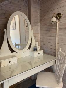 a dressing table with a mirror and a chair at Łajba-noclegi na wydmie in Stegna