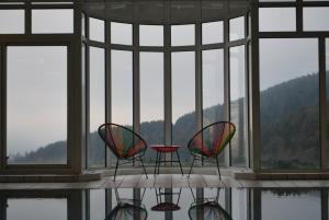 three chairs and a table in front of a window at Hôtel Panorama in Munster