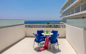 balcón con mesa, sillas y vistas al océano en Tofinis Hotel en Ayia Napa