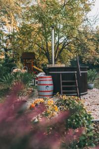 a garden with a barrel and a playground in the background at Csónakos ház / The boat house in Badacsonyörs