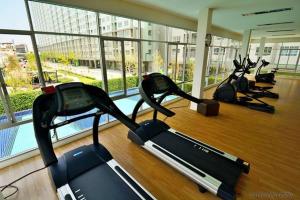 a gym with three cardio machines in a building at Nice Condo near Ramkhamhaeng 60, Lam Sali MRT in Bangkok
