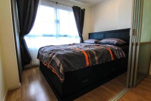 a bed in a room with a window and a mirror at Nice Condo near Ramkhamhaeng 60, Lam Sali MRT in Bangkok +7 photos