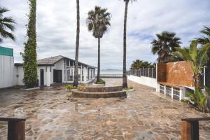 a courtyard with palm trees and a fountain at Posada del MAR in Ensenada