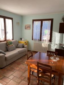 ein Wohnzimmer mit einem Sofa und einem Tisch in der Unterkunft CA' DEI GELSI B & B in Coriano