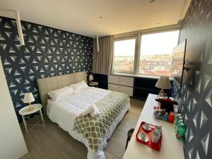 ナポリにある2B Fifteen Floor Suite Napoliのベッドルーム1室(ベッド1台、テーブル、窓付)