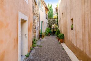 an alley way between two buildings with plants at Maison de village in Bonnieux