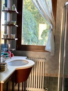 a bathroom with a sink and a window and a radiator at CA' DEI GELSI B & B in Coriano