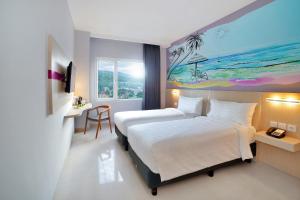 favehotel Bitung في بيتونغْ: غرفة فندق فيها سرير و لوحة على الحائط