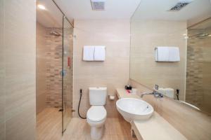 a bathroom with a toilet and a sink and a shower at favehotel Bitung in Bitung