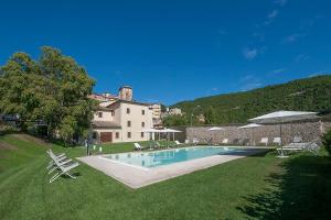a large house with a swimming pool in a yard at Hotel La Corte in Cascia