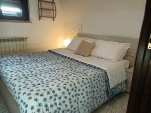 a bed with a blue and white blanket and pillows at Residence Speedy in Fiumicino