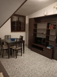 a dining room with a table and chairs and a entertainment center at Residence Speedy in Fiumicino